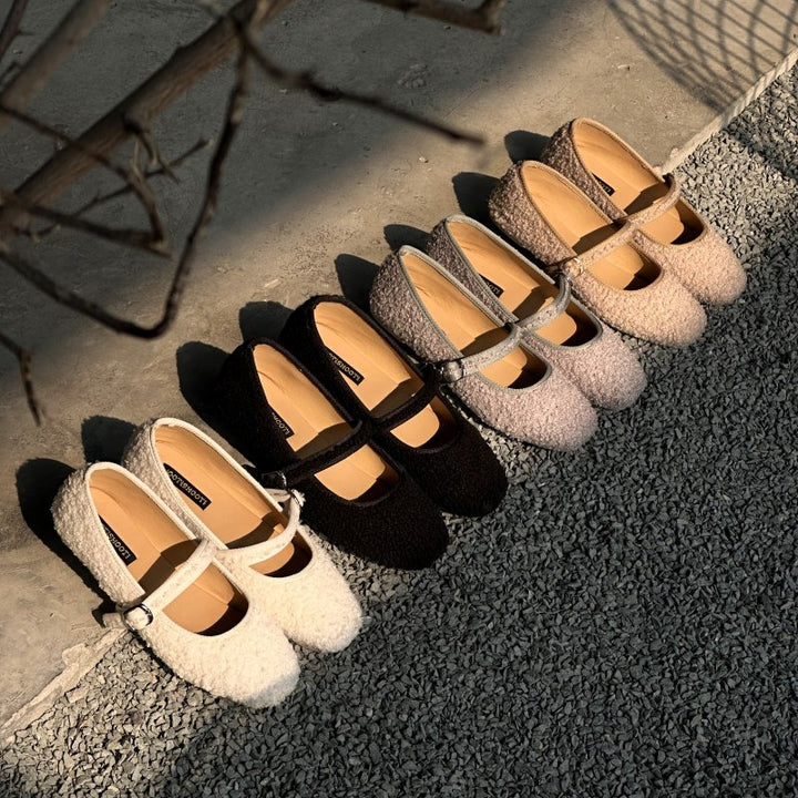 Set of four pairs of flat shoes arranged on a textured surface Boucle Mary Jane