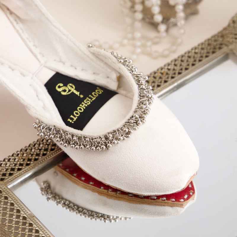 “Close-up of Beaded Halo White Khussa shoes highlighting smooth leather and minimal beadwork”